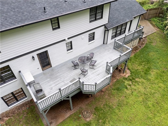 rear view of house with a shingled roof, a deck, stairs, and brick siding