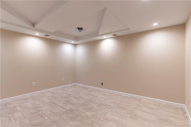 empty room with recessed lighting, baseboards, and a raised ceiling