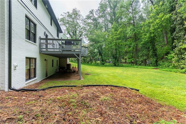 view of green lawn featuring a deck