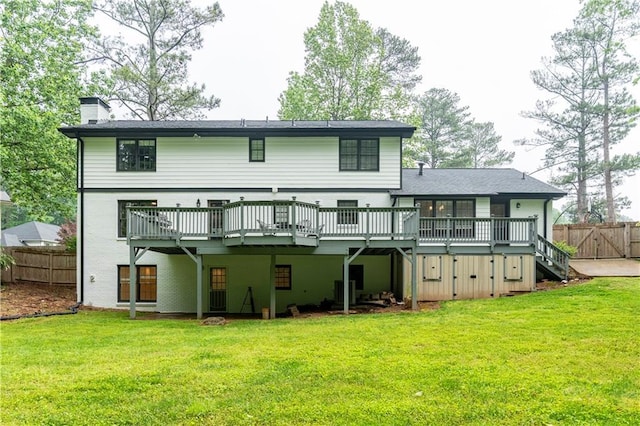 back of house with a wooden deck, a chimney, and a gate