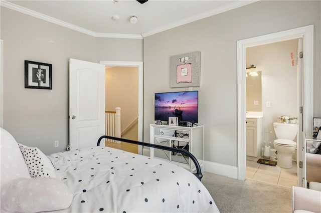 carpeted bedroom with ensuite bathroom and ornamental molding