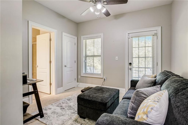 carpeted living room featuring ceiling fan and a wealth of natural light