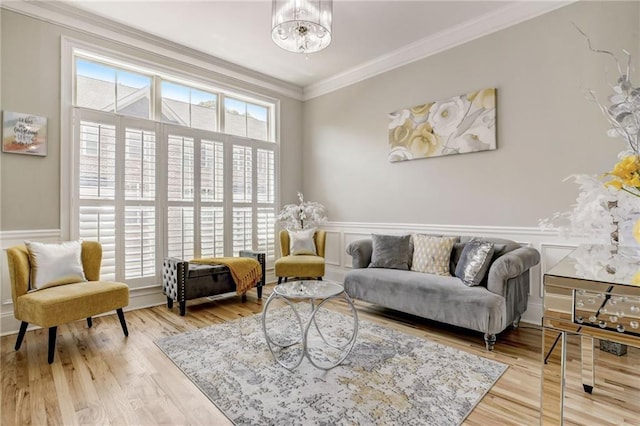 living area featuring crown molding, hardwood / wood-style floors, and a notable chandelier