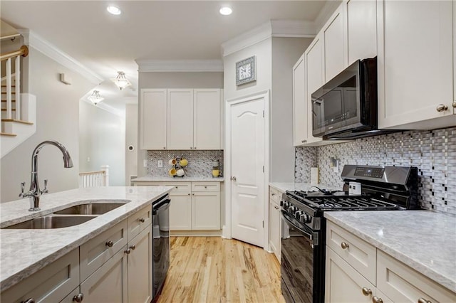 kitchen with sink, gas range oven, dishwasher, and light stone countertops