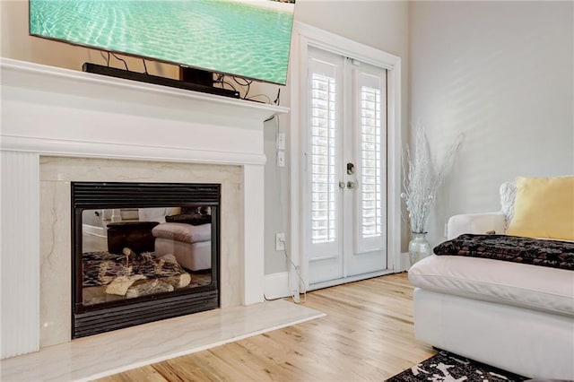 interior space with hardwood / wood-style floors, a high end fireplace, and french doors