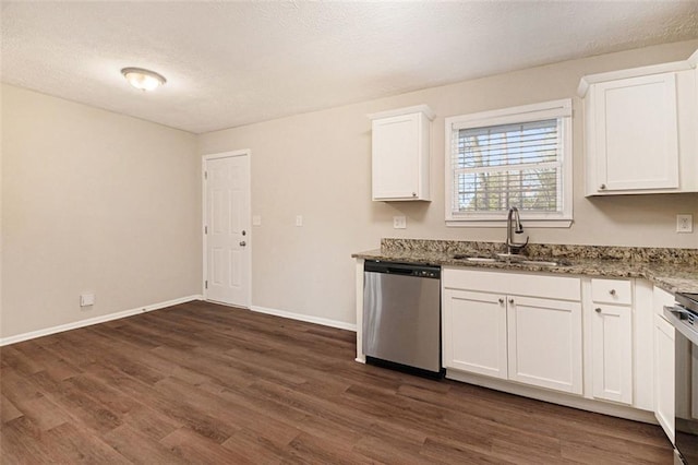 kitchen featuring stainless steel dishwasher, dark hardwood / wood-style flooring, white cabinets, dark stone counters, and sink