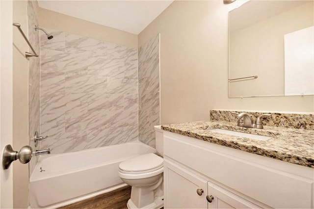 full bathroom with toilet, hardwood / wood-style flooring, tiled shower / bath combo, and vanity