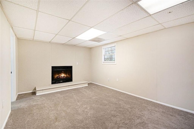 basement with carpet floors and a paneled ceiling