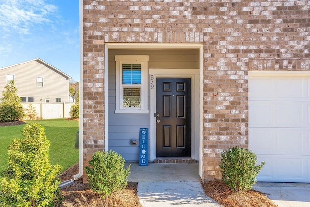 property entrance featuring a garage and a lawn