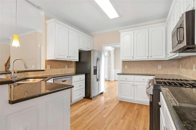 kitchen featuring sink, white cabinetry, crown molding, pendant lighting, and stainless steel appliances