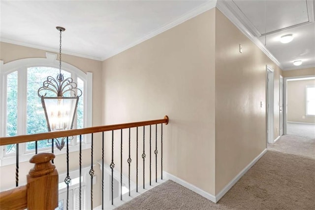 hallway with ornamental molding, carpet, and a notable chandelier