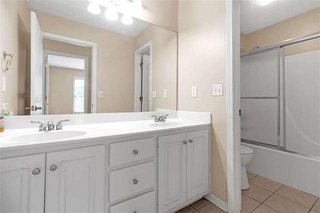 full bathroom with vanity, tile patterned floors, shower / bath combination with glass door, and toilet