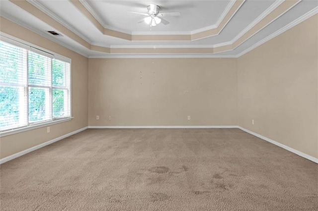 empty room featuring ceiling fan, carpet flooring, ornamental molding, and a tray ceiling