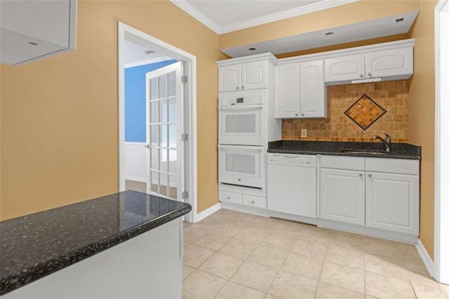 kitchen featuring sink, white appliances, dark stone counters, and white cabinets