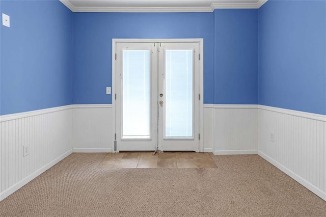 entryway with ornamental molding, light colored carpet, and french doors