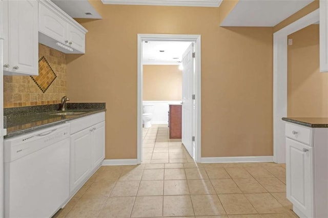 kitchen with sink, dishwasher, dark stone countertops, white cabinets, and light tile patterned flooring