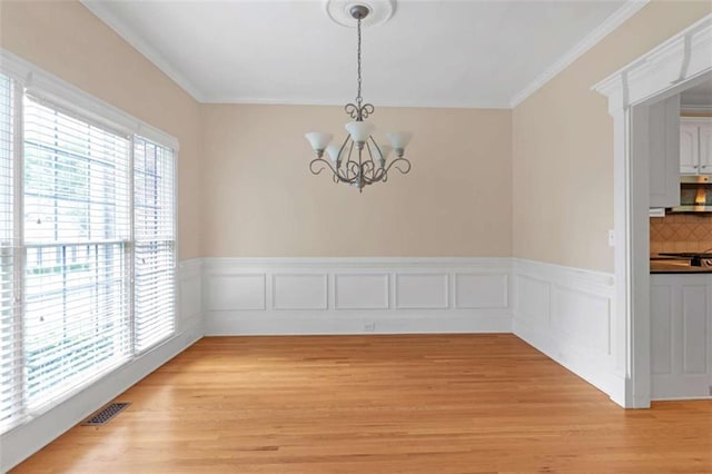 unfurnished dining area featuring an inviting chandelier, light hardwood / wood-style floors, and a wealth of natural light