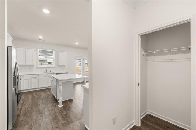 1159 Blue Juniper Cir, Loganville, GA 30052 - kitchen featuring white cabinets, dark wood-style floors, stainless steel refrigerator with ice dispenser, light countertops, and a center island