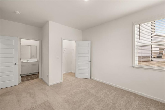 1159 Blue Juniper Cir, Loganville, GA 30052 - unfurnished bedroom with light colored carpet, baseboards, a walk in closet, ensuite bath, and a closet