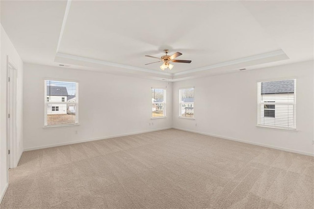 1159 Blue Juniper Cir, Loganville, GA 30052 - empty room featuring a tray ceiling, ceiling fan, light carpet, and crown molding