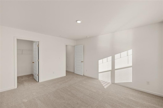1159 Blue Juniper Cir, Loganville, GA 30052 - unfurnished bedroom featuring light colored carpet, a walk in closet, baseboards, and a closet