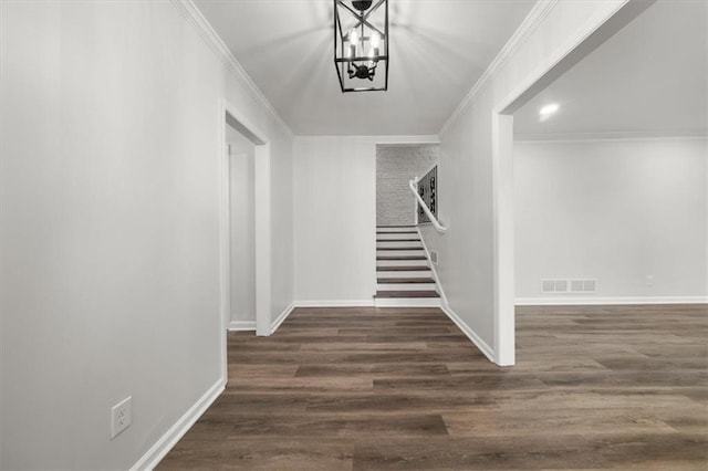 foyer entrance featuring ornamental molding, dark hardwood / wood-style floors, and an inviting chandelier