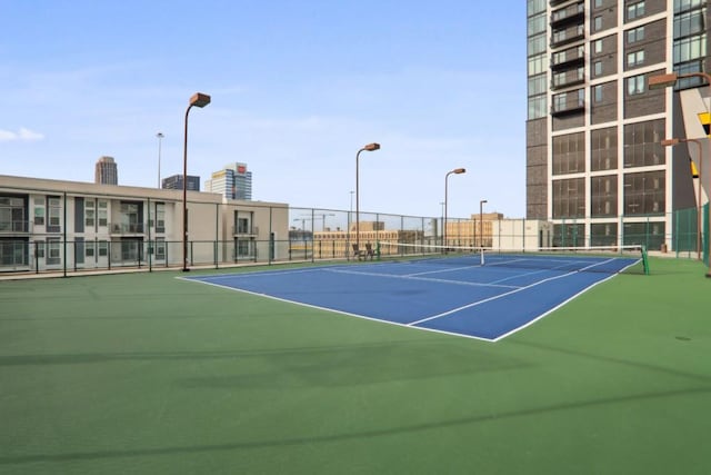 view of tennis court featuring fence