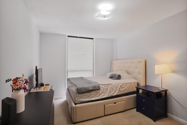 bedroom with baseboards and light carpet