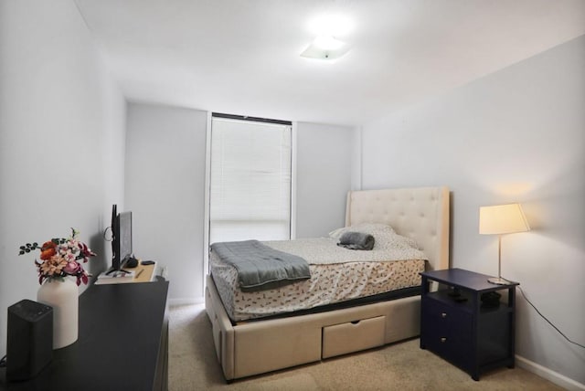 bedroom with light colored carpet and baseboards