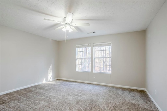 unfurnished room with a textured ceiling, carpet floors, and ceiling fan