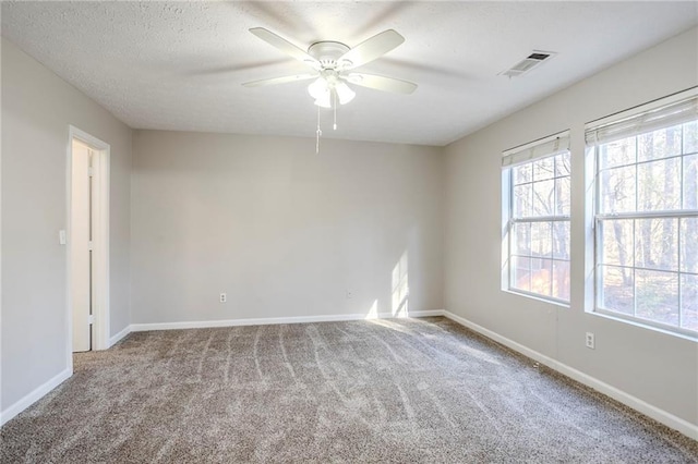 empty room with ceiling fan and light carpet