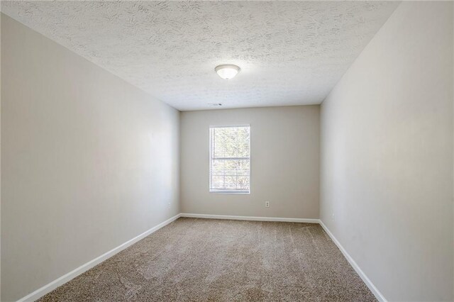 unfurnished room with carpet flooring and a textured ceiling