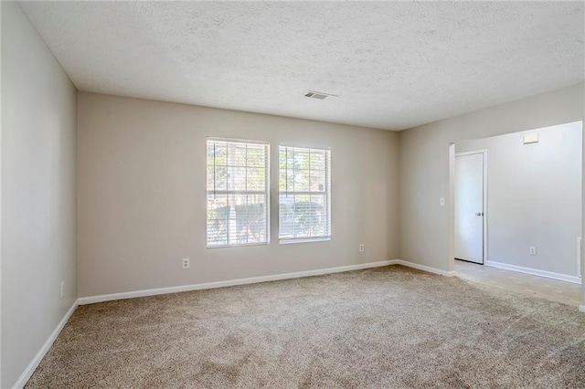 spare room featuring carpet floors and a textured ceiling