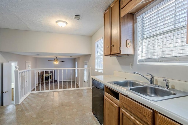 kitchen with ceiling fan, sink, a textured ceiling, and black dishwasher