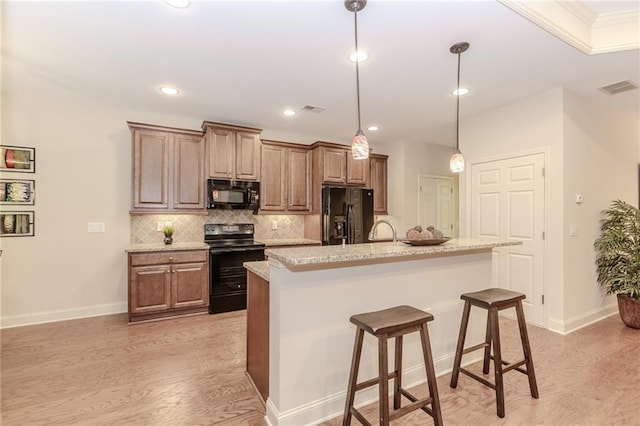 1555 Water Vista Ct Unit 4102, Cumming, GA 30041 - kitchen with black appliances, light wood finished floors, tasteful backsplash, a kitchen bar, and ornamental molding