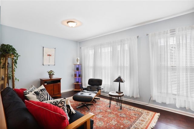 sitting room featuring a healthy amount of sunlight, dark wood-type flooring, and baseboards