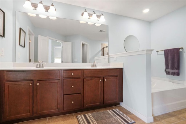 bathroom featuring a sink, a bath, double vanity, and tile patterned flooring