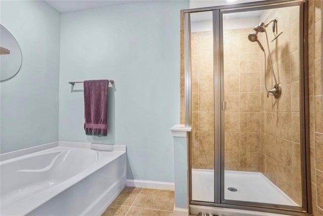 bathroom with baseboards, a garden tub, a shower stall, and tile patterned flooring