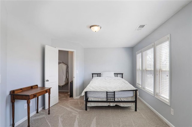 bedroom with visible vents, light colored carpet, and baseboards