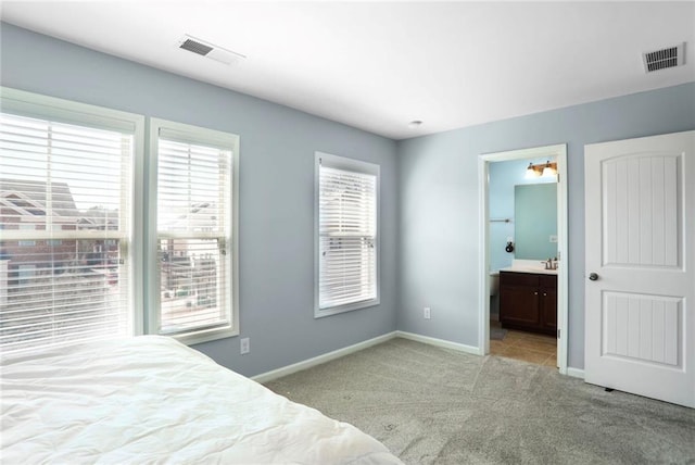 unfurnished bedroom with a sink, visible vents, carpet floors, and baseboards