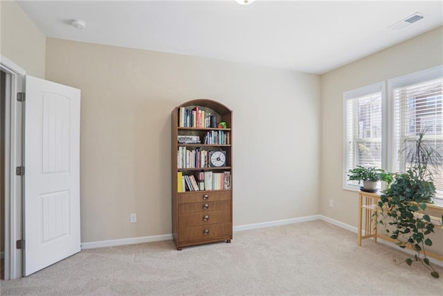 interior space featuring visible vents, baseboards, and carpet