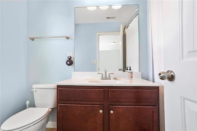 bathroom featuring visible vents, toilet, and vanity