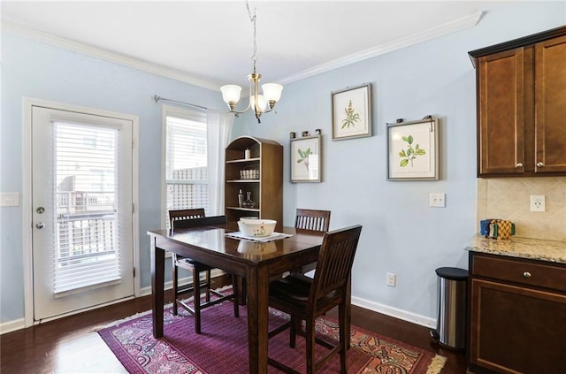 dining space with baseboards, an inviting chandelier, dark wood-style floors, and crown molding