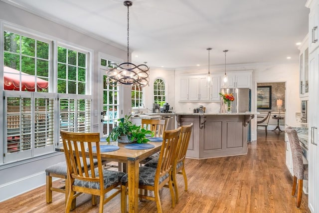 dining area featuring healthy amount of natural light, a chandelier, light wood-style floors, recessed lighting, and crown molding