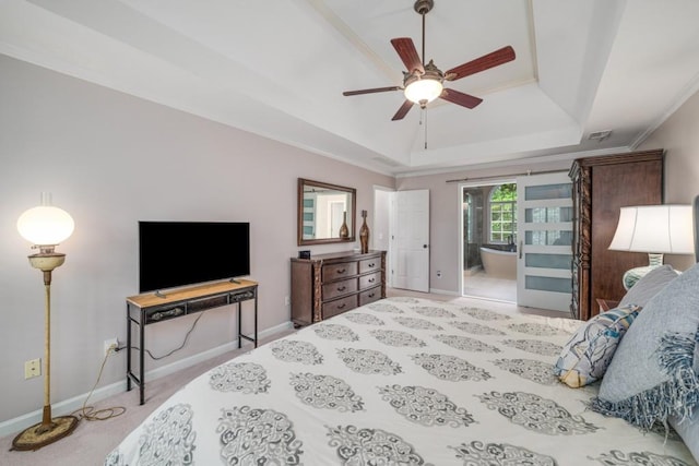 bedroom featuring a tray ceiling, baseboards, carpet flooring, and connected bathroom