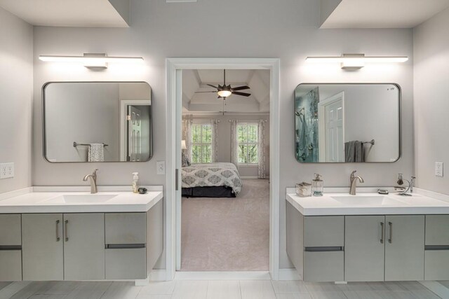 bathroom featuring ceiling fan, two vanities, connected bathroom, and baseboards