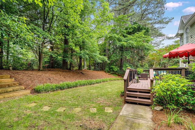 view of green lawn with a wooden deck
