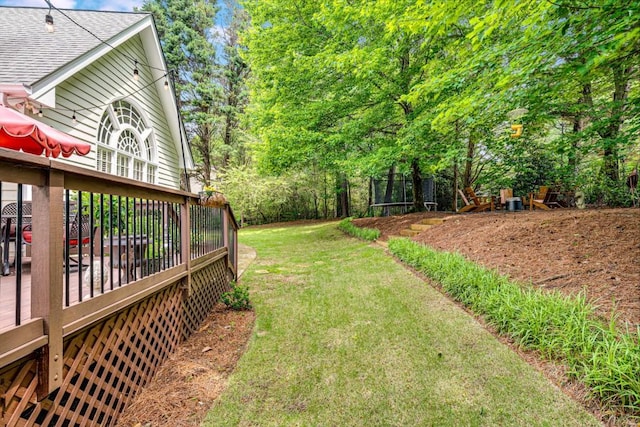 view of green lawn featuring a wooden deck