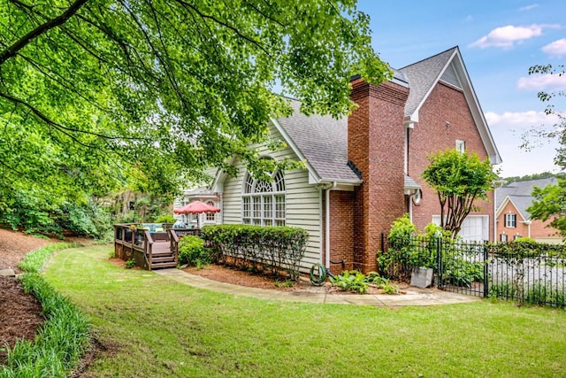 view of property exterior with roof with shingles, a chimney, a wooden deck, and brick siding