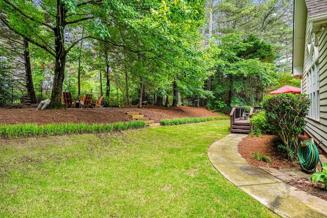 view of grassy yard with a deck
